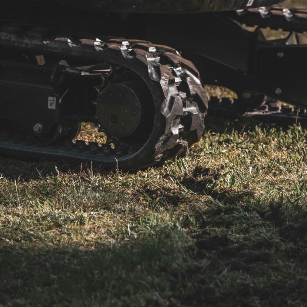 Compact excavator tracks on a residential lawn
